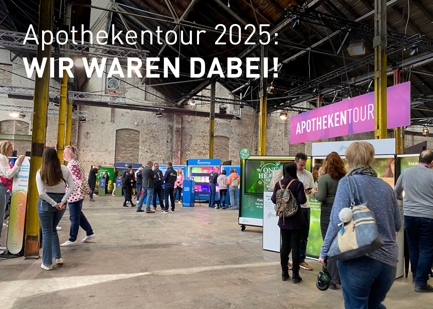 Messehalle mit Ständen und Besucher*innen