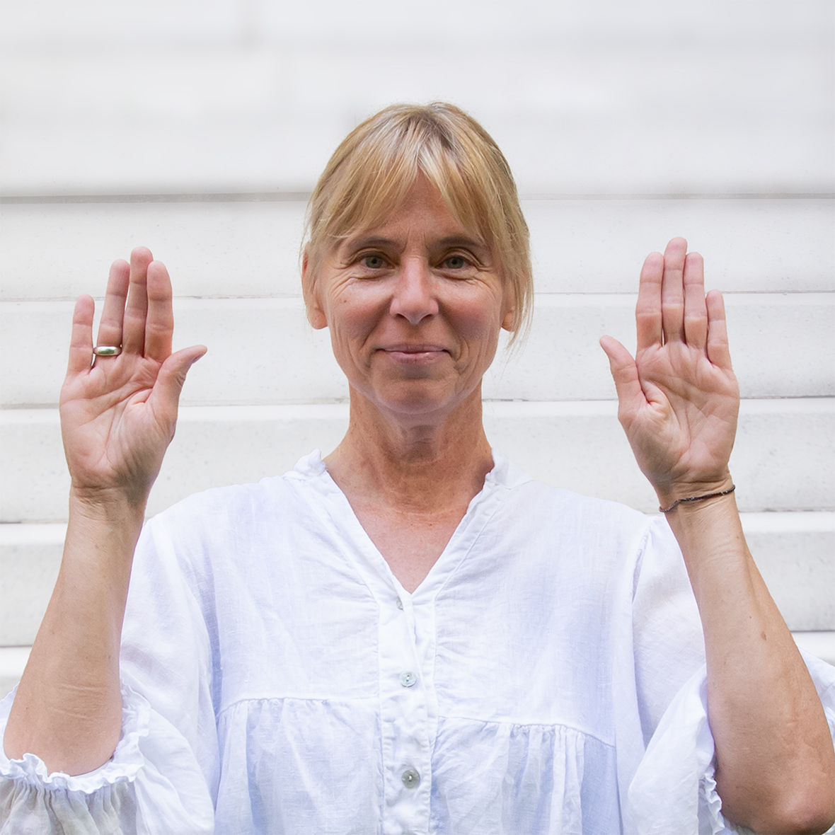 Sigrid Clauß mit den Händen neben dem Kopf