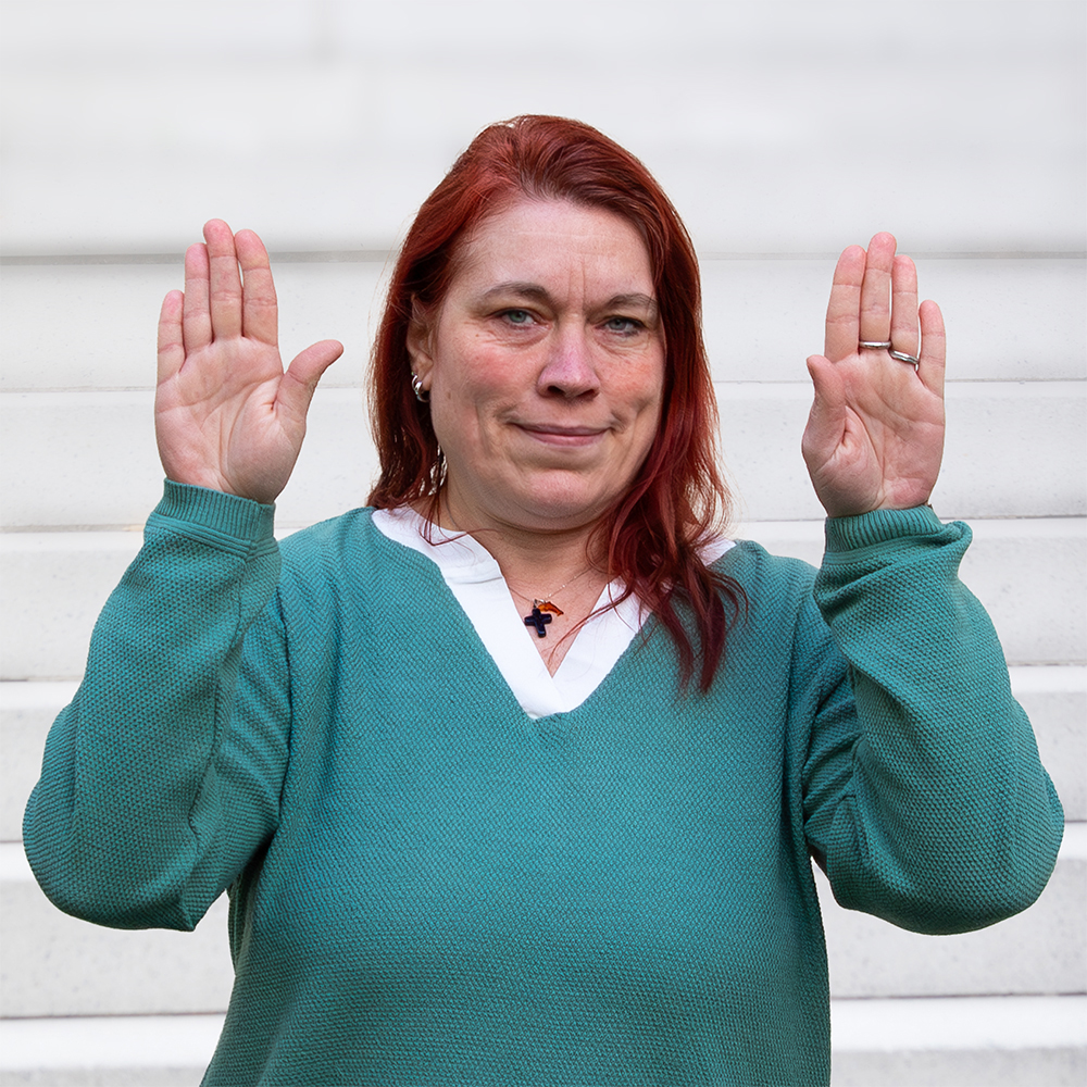 Daniele Seelisch übernimmt seit März 2026 die Administration bei Göbel und Gröner Grafisches Atelier. Sie hält die Hände neben dem Gesicht